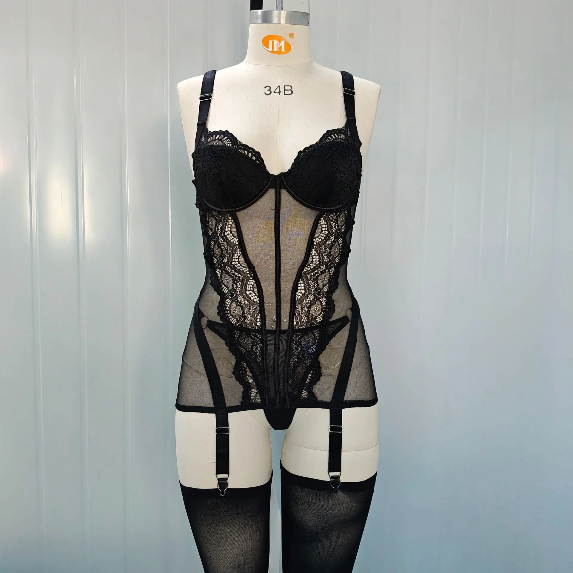 Black lace lingerie set on a mannequin against a plain background