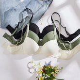 Set of bras in various colors on a white surface with flowers and denim jeans.