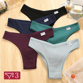 Set of three pairs of men's underwear in black, blue, and green on a wooden surface.