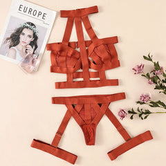 Red strappy lingerie set on a beige surface with flowers and a magazine.