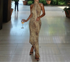 Woman in a leopard print dress holding a glass of wine on a tiled floor.