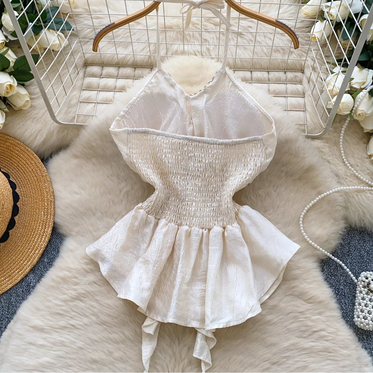 White lace dress on a wooden hanger with decorative elements on a textured surface