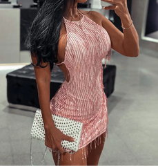 Woman in a pink dress taking a mirror selfie in an indoor setting.