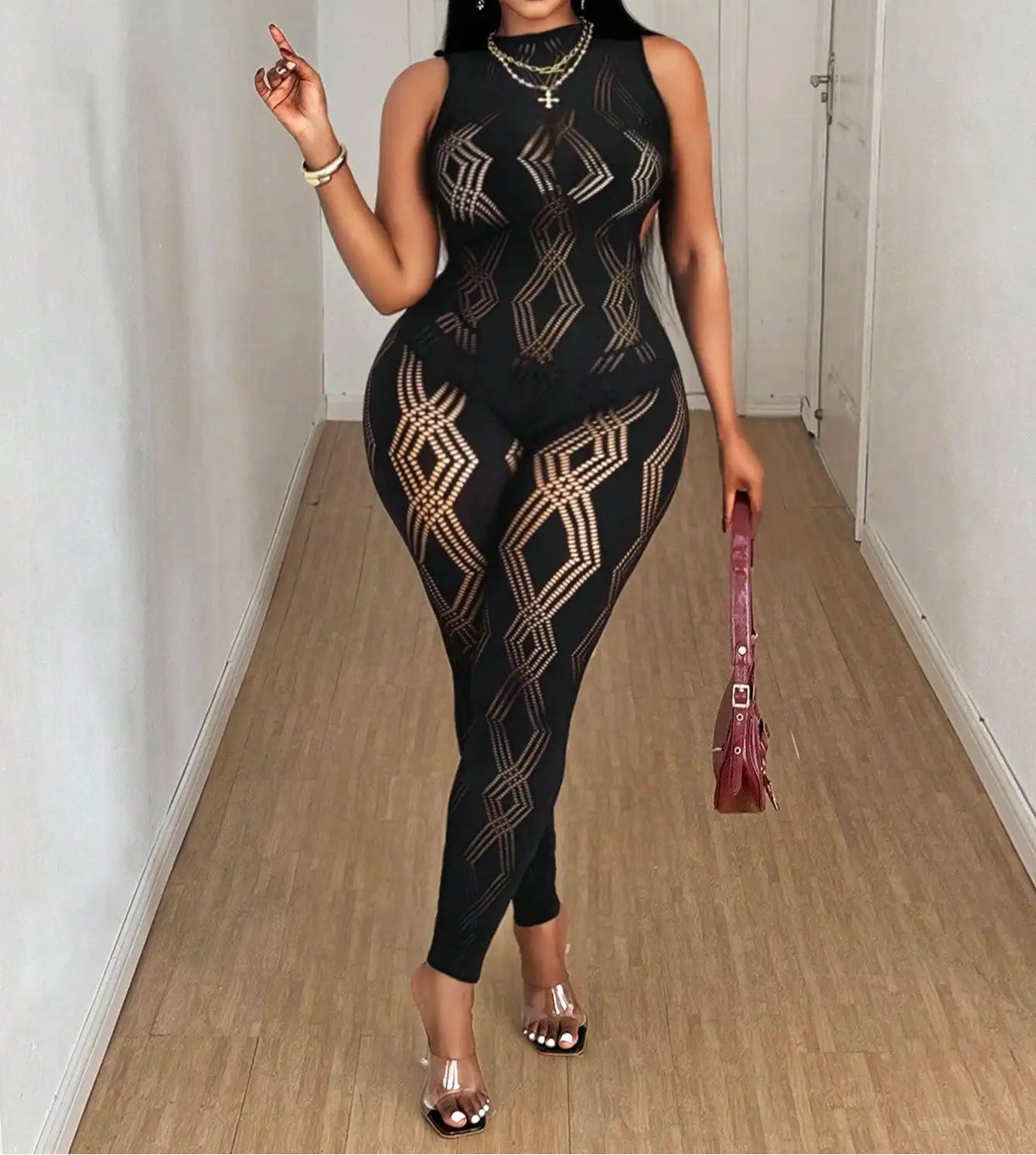 Woman in a black and gold patterned outfit standing in a hallway.