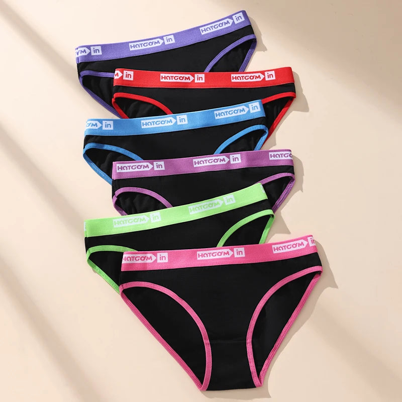 Set of black underwear with colorful waistbands on a beige background