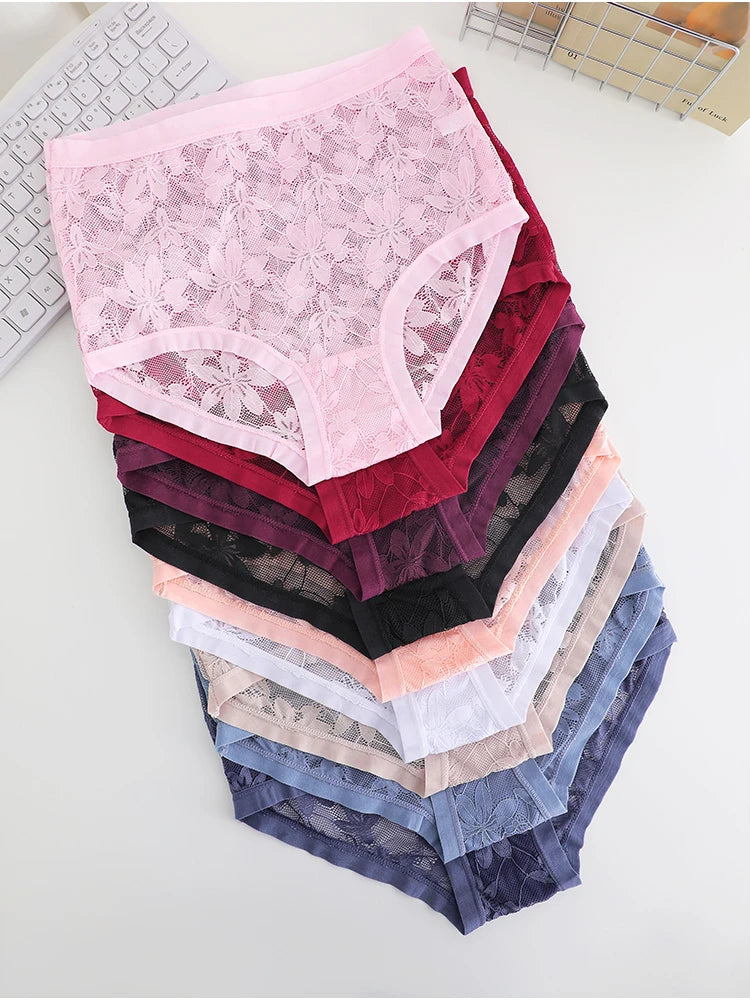Stack of lace underwear in various colors on a white surface.