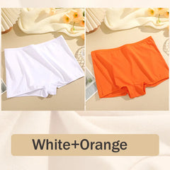 Two pairs of underwear, one white and one orange, on a beige surface with flowers.