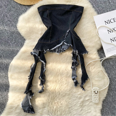 Black denim skirt with frayed edges on a textured surface with a hat and Nike tag.