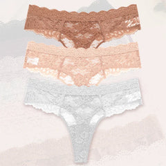Set of three lace underwear pieces in different colors on a textured background