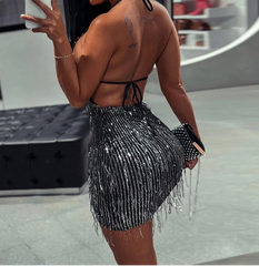 Woman taking a mirror selfie wearing a black beaded outfit.