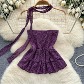 Purple lace dress on a hanger with floral decorations in the background