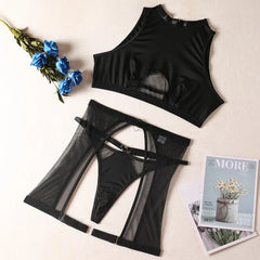 Black sheer lingerie set with a magazine and flowers on a light background