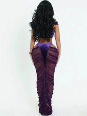 Woman wearing a purple dress with a sheer overlay on a white background