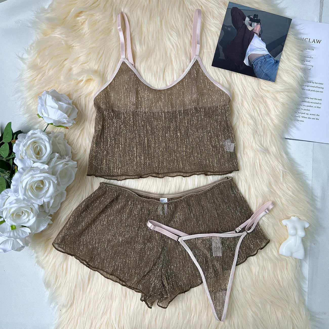 Brown lingerie set on a fluffy white surface with flowers and a magazine.