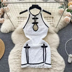 White dress with black accents on a hanger against a decorative background