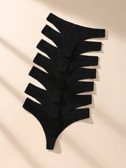 7 black thong-style underwear on a beige fabric background