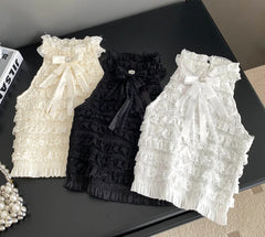 Three lace pet dresses in white, black, and cream on a black surface.
