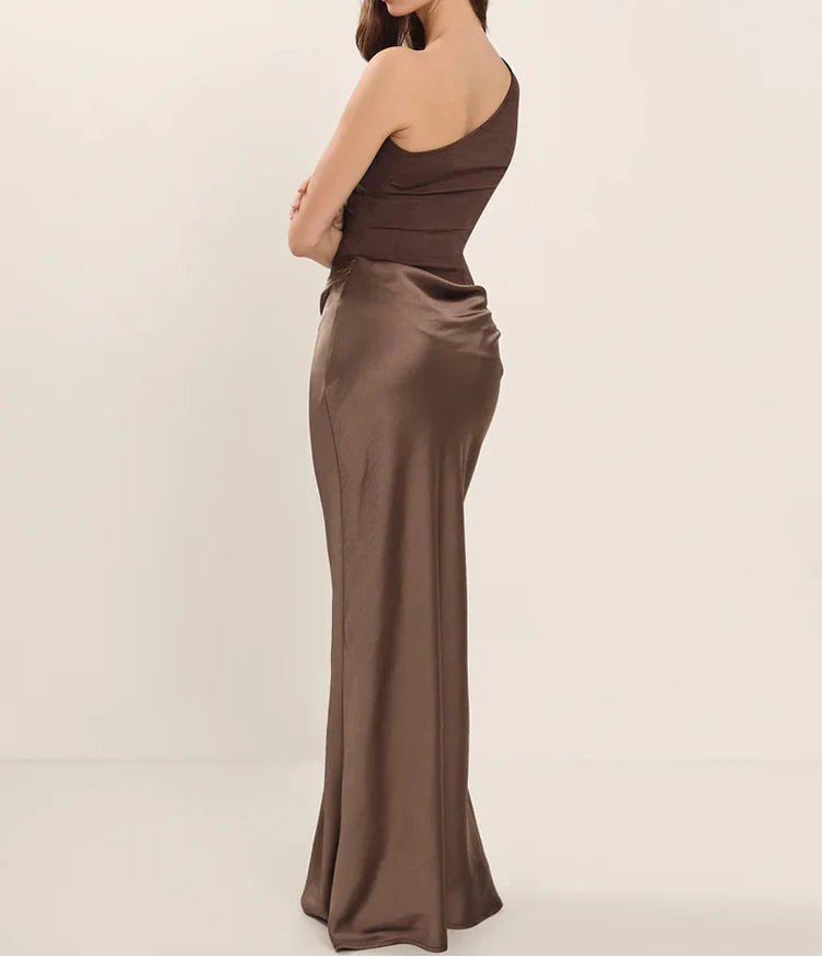 Woman wearing a brown evening gown against a plain background