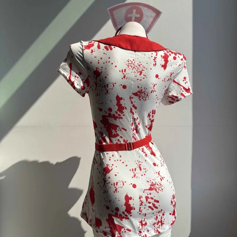 Mannequin wearing a white dress with red blood splatter against a plain background