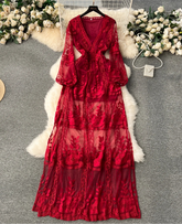 Red lace dress on a hanger with floral decorations on a gray surface