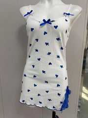 White dress with blue heart patterns on a mannequin against a neutral background