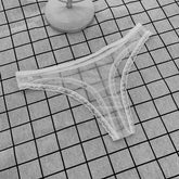 Lace-trimmed underwear on a grid-patterned surface