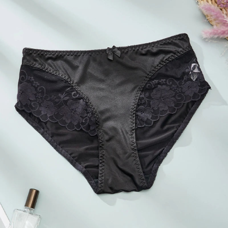 Black lace underwear on a light gray background with a perfume bottle.