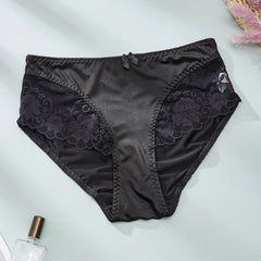 Black lace underwear on a light gray background with a perfume bottle.