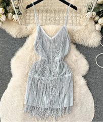 Gray fringe dress on a hanger with decorative background