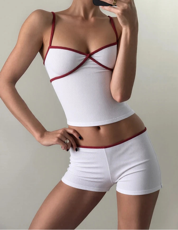 Person wearing a white and red sports bra and shorts set against a neutral background
