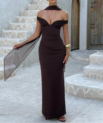 Woman in a dark brown off-shoulder gown standing on stone steps.