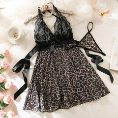 Leopard print dress with black lace top on a white surface with flowers and jewelry.