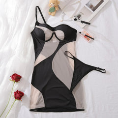Black lingerie set on a white surface with a teddy bear, roses, and makeup items.