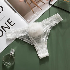 White lace thong on a green surface with a magazine in the background