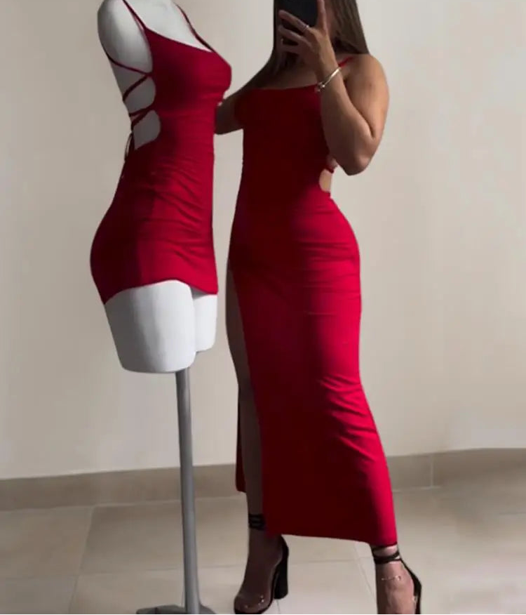 Woman wearing a red dress standing next to a mannequin also wearing a red dress.