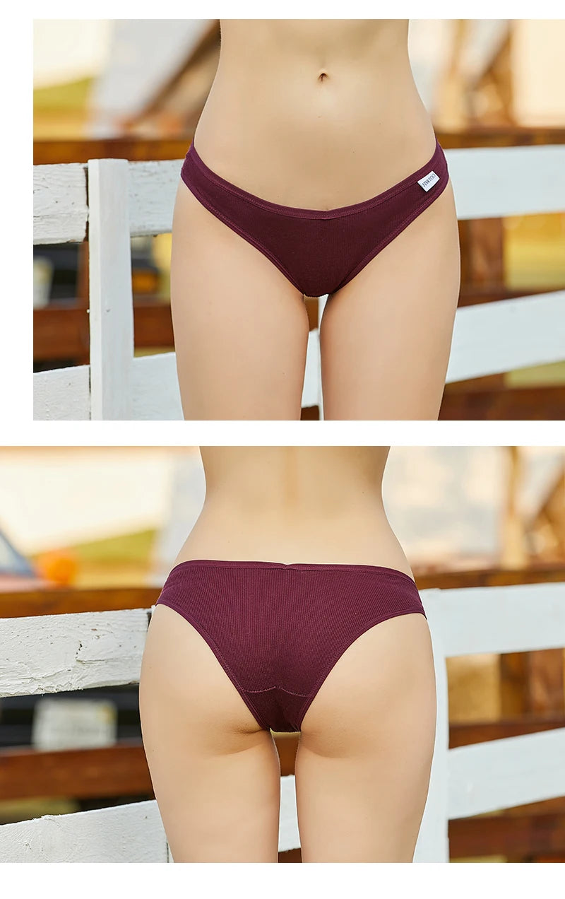 Maroon bikini bottom worn by a person on a blurred outdoor background