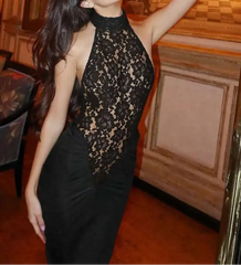Woman in a black lace dress posing in an elegant interior setting
