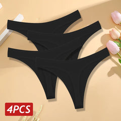Four black thongs on a beige background with pink flowers.