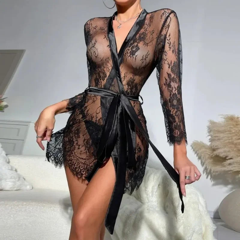 Person wearing a black lace robe in a neutral setting
