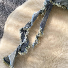 Gray dog rope toy on a fluffy beige surface