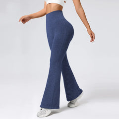 Person wearing blue ribbed flared pants on a white background