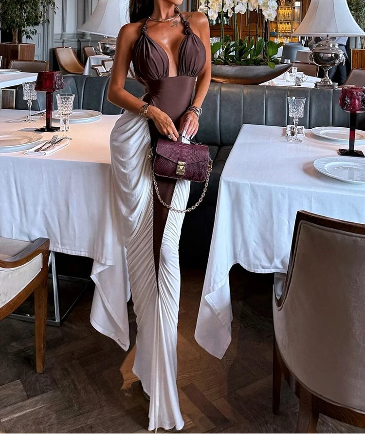 Woman in a stylish outfit standing in a restaurant with tables and decor.
