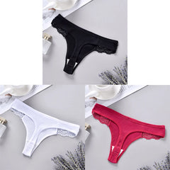 Three pairs of lace-trimmed panties in black, white, and red on a light gray surface.