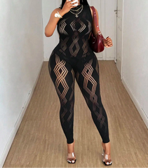 Person wearing a black patterned jumpsuit taking a mirror selfie.