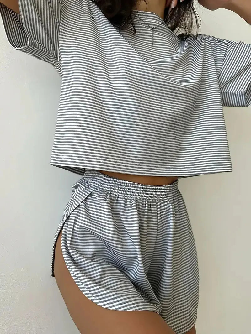 Person wearing a black and white striped outfit with a crop top and shorts on a plain background