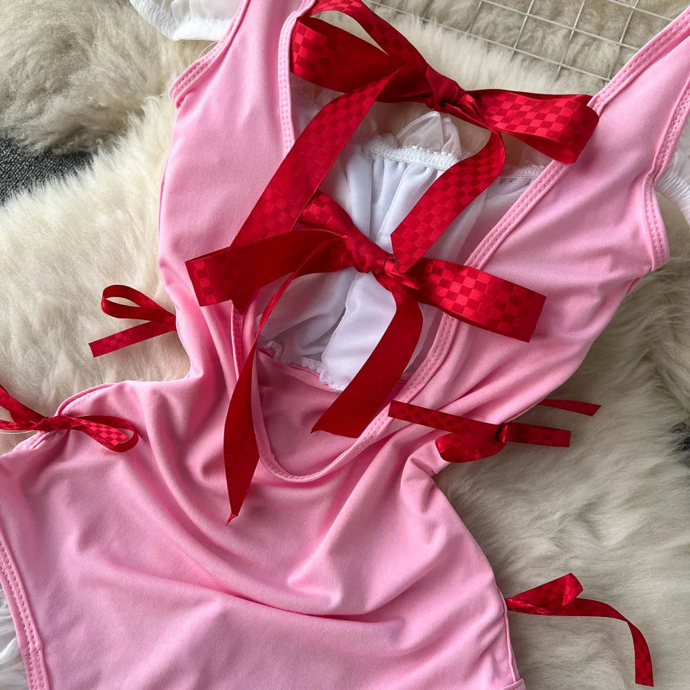 Pink bikini with red ribbons on a textured surface