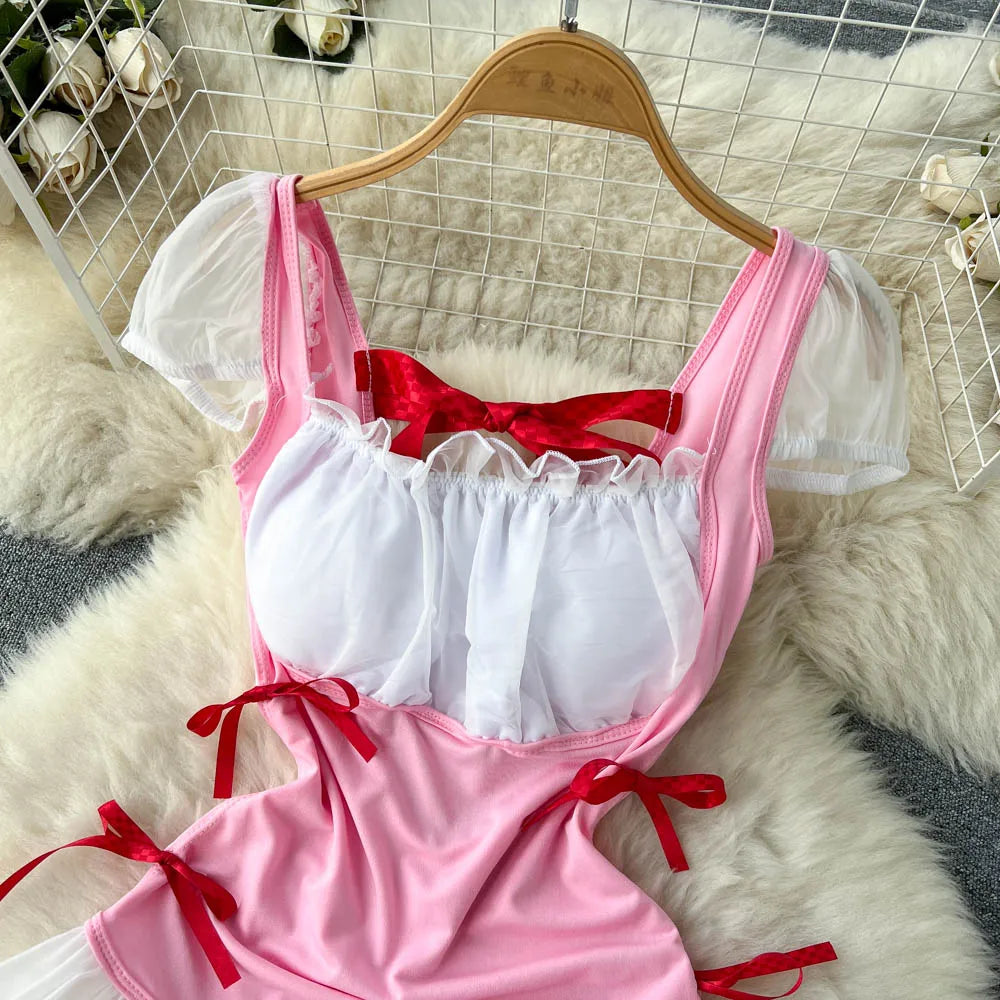 Pink and white lingerie set with red ribbons on a hanger against a textured white background.