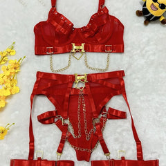 Red lingerie set with gold chains on a textured white background with yellow flowers and a plush toy.