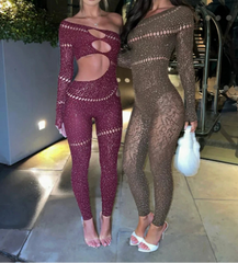 Two women in sparkly, form-fitting outfits standing in an indoor setting with plants.