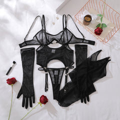 Black lingerie set with garter belt, bra, panties, and gloves on a white surface with red roses.